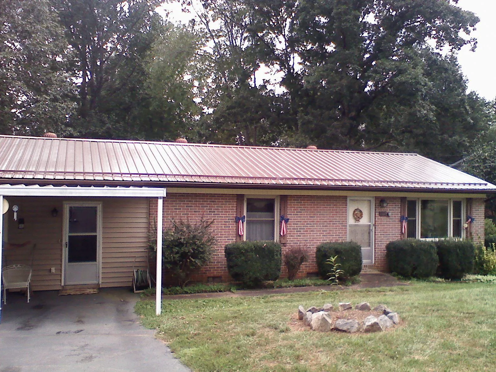 Bronze metal roof and carport on a brick ranch home — Roof Repair work by our crew in Pleasant Hill